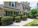 Tan home featuring meticulously trimmed bushes and a concrete walkway at 115 Dunlavin Dr, Acworth, GA 30102