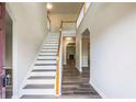 Bright foyer featuring hardwood floors and a staircase with white risers and wood railing at 1849 Wanda Way, Ellenwood, GA 30294