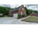 View of the side exterior showing a large garage, basketball hoop and a well-maintained yard at 1200 Martins Chapel Se Ln, Lawrenceville, GA 30045