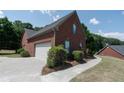 View of the side exterior showing a large garage, basketball hoop and a well-maintained yard at 1200 Martins Chapel Se Ln, Lawrenceville, GA 30045