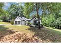 Charming one-story home with a two-car garage surrounded by lush greenery and trees at 3021 Stone Bridge Sw Trl, Conyers, GA 30094
