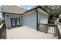 Back deck with gray wood, black french doors, and a view of the garage at 3871 Portland Trail Dr, Suwanee, GA 30024