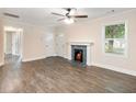 Bright living room with a decorative fireplace, new flooring, and a ceiling fan for added comfort at 1560 Pontiac Se Pl, Atlanta, GA 30315