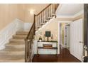 Bright foyer featuring hardwood floors, paneled walls, and staircase with wood banister at 7575 Hunters Woods W Dr, Atlanta, GA 30350