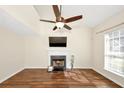 Inviting living room featuring hardwood floors, a cozy fireplace, ceiling fan, and bright natural light at 1338 Gates Se Dr, Atlanta, GA 30316