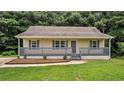Charming home with a covered front porch, gray trim, and a well-manicured lawn at 35 Ravenwood Dr, Rockmart, GA 30153