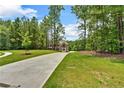 Wide concrete driveway leading to a well-manicured lawn and a two-story brick home at 7449 Waterview Cv, Douglasville, GA 30135
