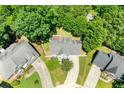 Aerial view of a well-maintained home with a gray roof, surrounded by lush trees and neighboring houses at 1095 Northpoint Trce, Roswell, GA 30076