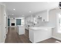 Modern kitchen with white cabinetry, quartz countertops, stainless steel appliances, and an open floor plan at 772 Brookwood Sw Ter, Lilburn, GA 30047