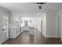 Spacious kitchen with white cabinets, marble countertops, hardwood floors, and modern lighting fixtures at 772 Brookwood Sw Ter, Lilburn, GA 30047