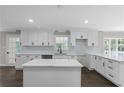 Bright kitchen with white cabinets, quartz countertops, subway tile backsplash, and a center island at 772 Brookwood Sw Ter, Lilburn, GA 30047