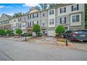 Street view of the townhome featuring a front yard, one car garage, and lush landscaping at 1768 Oakbrook Nw Ln # 9, Kennesaw, GA 30152