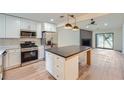 Open-concept kitchen with stainless steel appliances, island with breakfast bar, and modern lighting at 2027 Jebs Nw Ct, Kennesaw, GA 30144