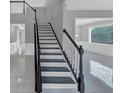 Open foyer with tiled floor and dark-stained staircase leading to the upper level at 27 Spur Ct, Hiram, GA 30141
