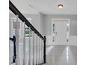 Bright foyer with tiled floor, staircase, and white front door and decorative molding at 27 Spur Ct, Hiram, GA 30141