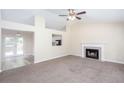 Spacious living room featuring a cozy fireplace, large windows, and an open layout leading to the kitchen at 1049 Braddock Cir, Woodstock, GA 30189