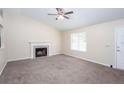 Inviting living room with plush carpeting, a fireplace, and natural light, creating a comfortable and welcoming space at 1049 Braddock Cir, Woodstock, GA 30189