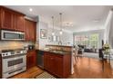 Well-equipped kitchen with stainless steel appliances, granite countertops, and sleek cherry cabinets at 1403 Ashford Creek Ne Cir, Atlanta, GA 30319