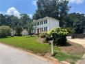 A two-story home with a manicured lawn and landscaping, plus a detached garage at 1725 Spindle Top Sw Ct, Lilburn, GA 30047