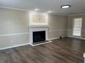 Bright living room with dark wood floors, neutral paint, and a fireplace with white mantel at 1725 Spindle Top Sw Ct, Lilburn, GA 30047