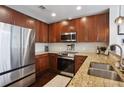 Close-up of kitchen featuring granite countertops, stainless steel appliances, and dark wood cabinetry at 855 Peachtree Ne St # 3005, Atlanta, GA 30308