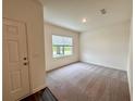 Inviting entryway featuring neutral carpet, a front door, and a window for natural light at 133 Bandimere Pkwy, Dallas, GA 30157