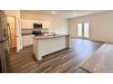 Open kitchen featuring an island with granite countertops, white cabinets, and stainless steel appliances at 133 Bandimere Pkwy, Dallas, GA 30157