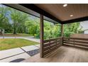 Inviting covered front porch with wood floors and railing, offering a view of the landscaped front yard and street at 1355 Lockwood Sw Dr, Atlanta, GA 30311
