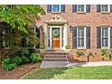 Close-up of a classic brick home's front door with decorative details and landscaping at 5130 Stoneywood Se Cir, Mableton, GA 30126