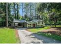 Charming home featuring a covered carport, a red front door, and a long driveway at 3195 Newcastle Way, Snellville, GA 30039