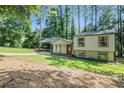 Charming home featuring a covered carport, a red front door, and a lush front yard at 3195 Newcastle Way, Snellville, GA 30039