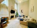 Bright and airy living room featuring soaring ceilings, a fireplace, and a large neutral sofa at 5771 Vinings Retreat Sw Way, Mableton, GA 30126