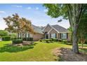 Well-maintained brick home with a lush green lawn, complemented by mature trees for added privacy and shade at 1506 Threepine Place Pl, Lilburn, GA 30047