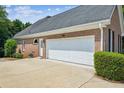 Spacious two-car garage with ample parking space, set against a well-kept brick exterior and landscaped surroundings at 1506 Threepine Place Pl, Lilburn, GA 30047