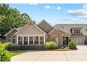 Beautiful home showcasing a well-maintained lawn, complemented by lush greenery and architectural details at 6042 Brookhaven Cir # 3202, Johns Creek, GA 30097