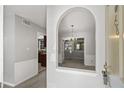 Inviting entryway featuring neutral tones and an arched opening to the dining room with chandelier at 68 La Rue Nw Pl, Atlanta, GA 30327