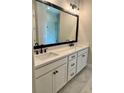 Modern bathroom with double sinks, a large mirror, and a glass-enclosed shower at 7220 Winderlea Ln, Cumming, GA 30040