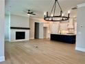 Spacious living room with fireplace and hardwood floors that seamlessly flows into a modern kitchen at 7220 Winderlea Ln, Cumming, GA 30040