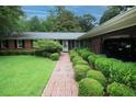 Charming front entrance with brick walkway, manicured shrubs, and covered parking at 742 Starlight Ne Ct, Sandy Springs, GA 30342