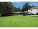 Single-story brick home featuring lush green lawn, mature trees, and a two-car carport at 742 Starlight Ne Ct, Sandy Springs, GA 30342