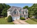 Charming two-story brick home with a well-manicured lawn, two-car garage and attractive shutters at 4345 Mantle Ridge Dr, Cumming, GA 30041