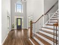 Elegant foyer with soaring ceilings, hardwood floors, staircase and front door with decorative glass insert at 4345 Mantle Ridge Dr, Cumming, GA 30041