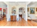 Elegant foyer featuring hardwood floors, a decorative mirror, and arched doorway leading to the living area at 8095 Georgetown Cir, Suwanee, GA 30024