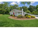 Lovely home with a green lawn, a chimney, and healthy shrubbery at 1480 Bettis Tribble Gap Rd, Cumming, GA 30040