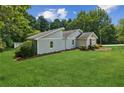 Well-maintained home on a large lot featuring lush green grass and healthy trees at 1480 Bettis Tribble Gap Rd, Cumming, GA 30040