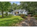 Well-maintained home with a driveway and lush lawn, surrounded by mature trees at 1617 Columbia Cir, Decatur, GA 30032