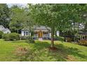 A cozy home with a covered porch is nestled amongst a mature tree landscape at 1617 Columbia Cir, Decatur, GA 30032
