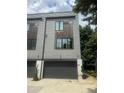 Modern townhouse with gray siding and a large garage door, providing convenient parking at 2424 Memorial Drive Se Dr # 7, Atlanta, GA 30317
