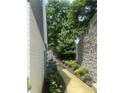 Landscaped walkway beside the house with stone retaining wall and lush greenery at 2424 Memorial Drive Se Dr # 7, Atlanta, GA 30317