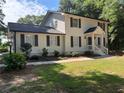 Traditional home exterior with white siding, black shutters, manicured lawn and inviting front porch with white railings at 1789 Springhouse Ct, Lawrenceville, GA 30043